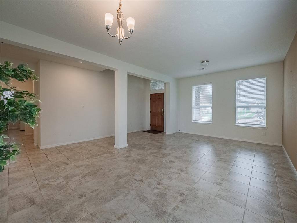 another view of the formal living and dining, which also has lots of windows for natural light the opening is to the garage door and laundry room and half bath