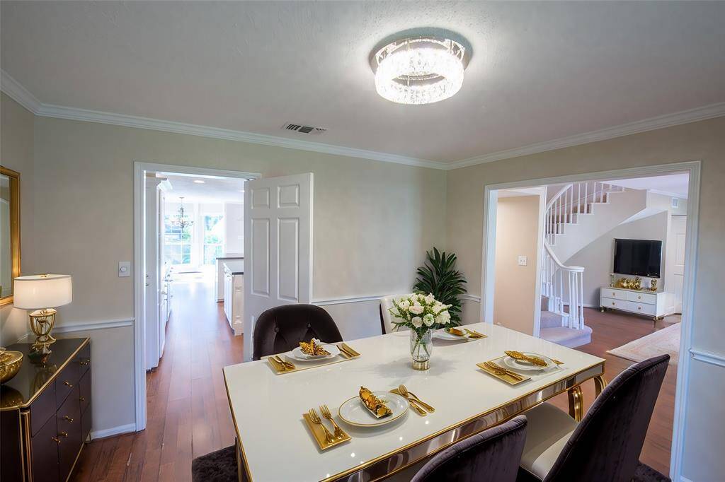 The formal dining rooms located just of the kitchen through the swinging door. You can see the entry way with the spirial staircase to the right.