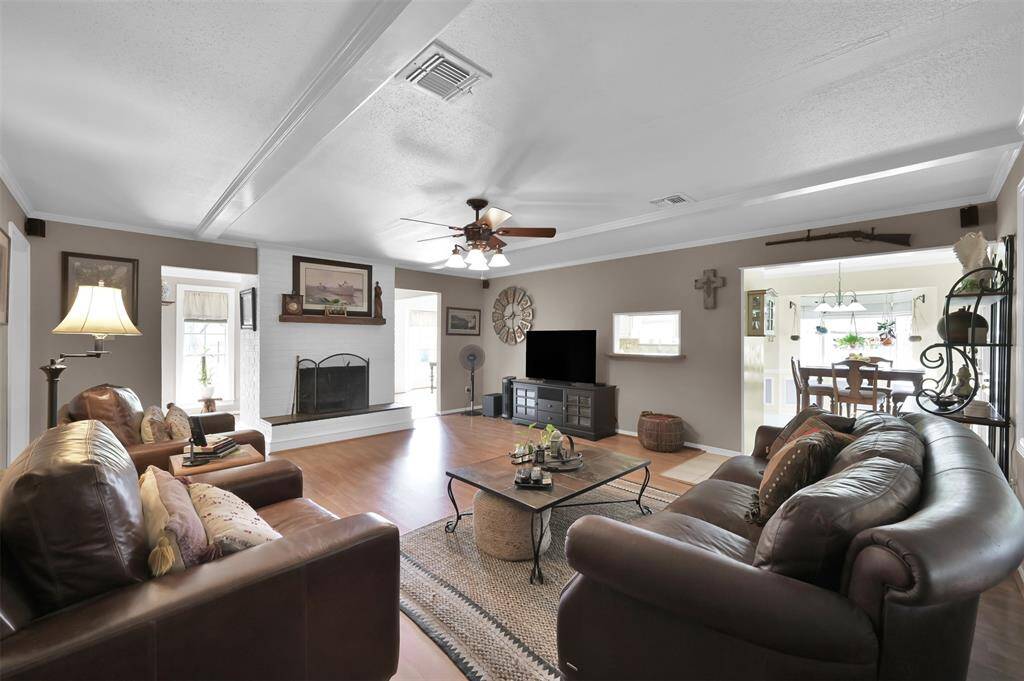 This spacious living room features a cozy fireplace flows into a bright dining area, ideal for entertaining