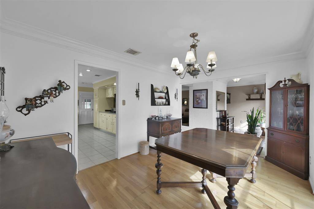 Dining room opens to kitchen with a glimpse of the cozy living area