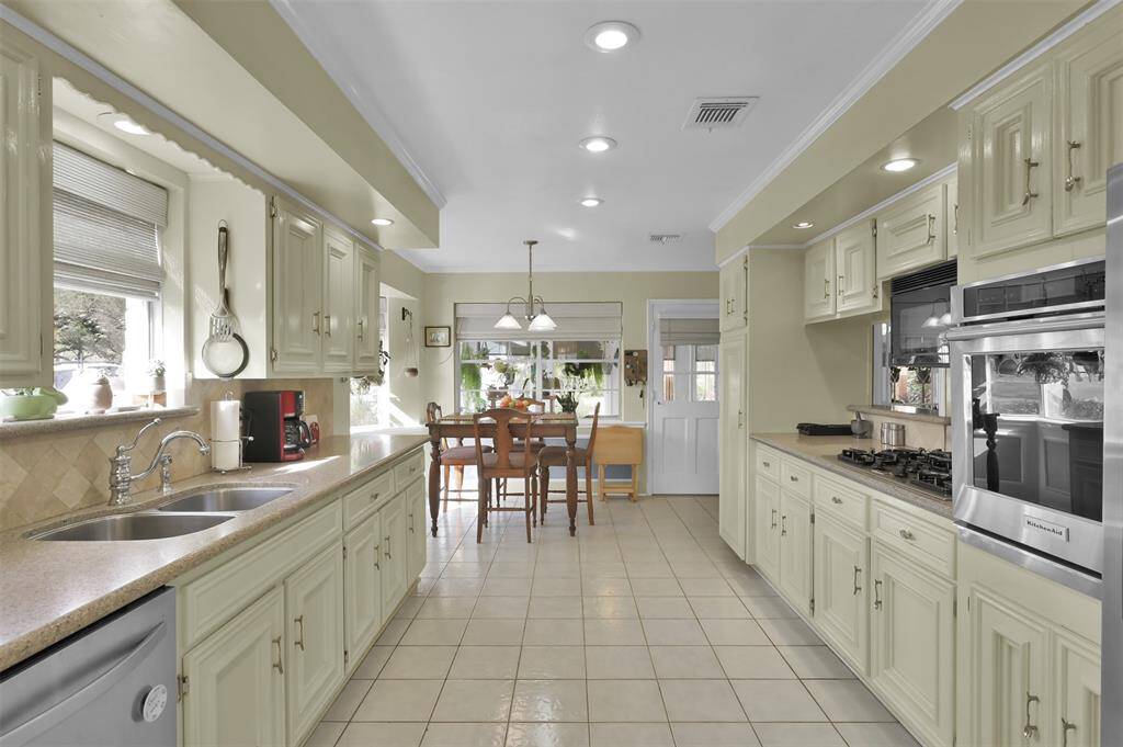 This kitchen features a spacious layout with light-colored cabinetry, modern stainless steel appliances, and ample counter space.