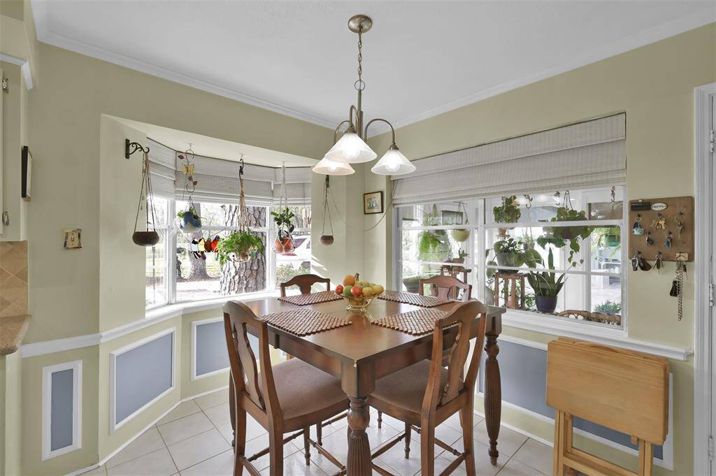 A cozy dining nook in the kitchen with large windows showcasing lush greenery