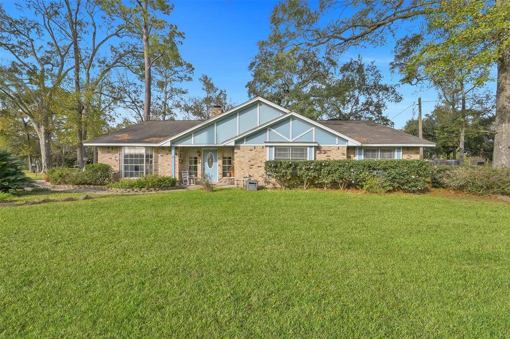 This charming single-story home features a classic brick exterior with blue accents and a welcoming front porch