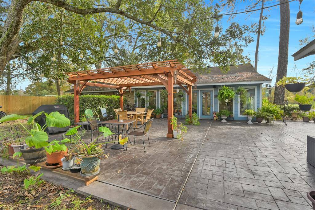 Spacious backyard with a charming pergola and patio area, ideal for outdoor dining and relaxation