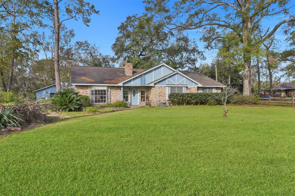 Charming single-story home with a spacious front yard, nestled among mature trees