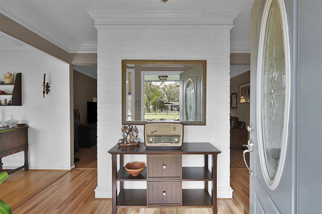 This entryway features a charming brick accent wall which leads into a bright living area & formal dining