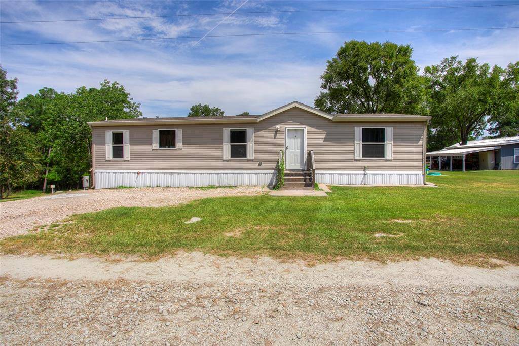 Front view of mobile home with designated parking spaces.