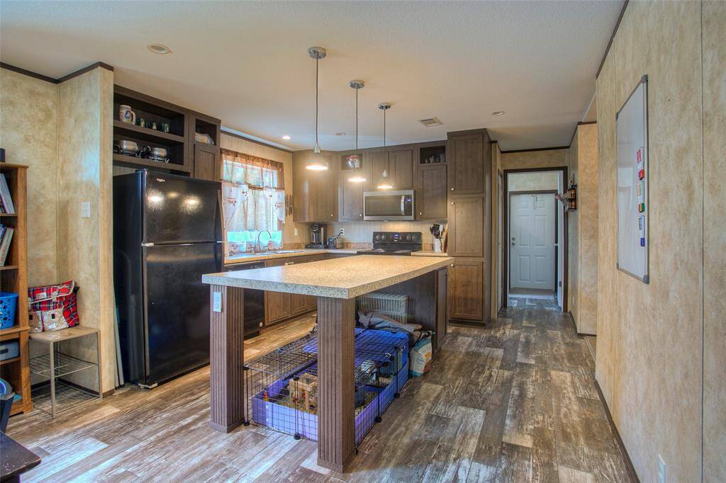 Kitchen with large island and hanging pendants.