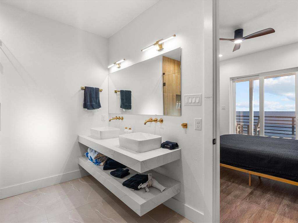 Elegant, modern bathroom featuring dual vessel sinks, sleek fixtures, and ample shelving—perfect for a stylish, functional space.