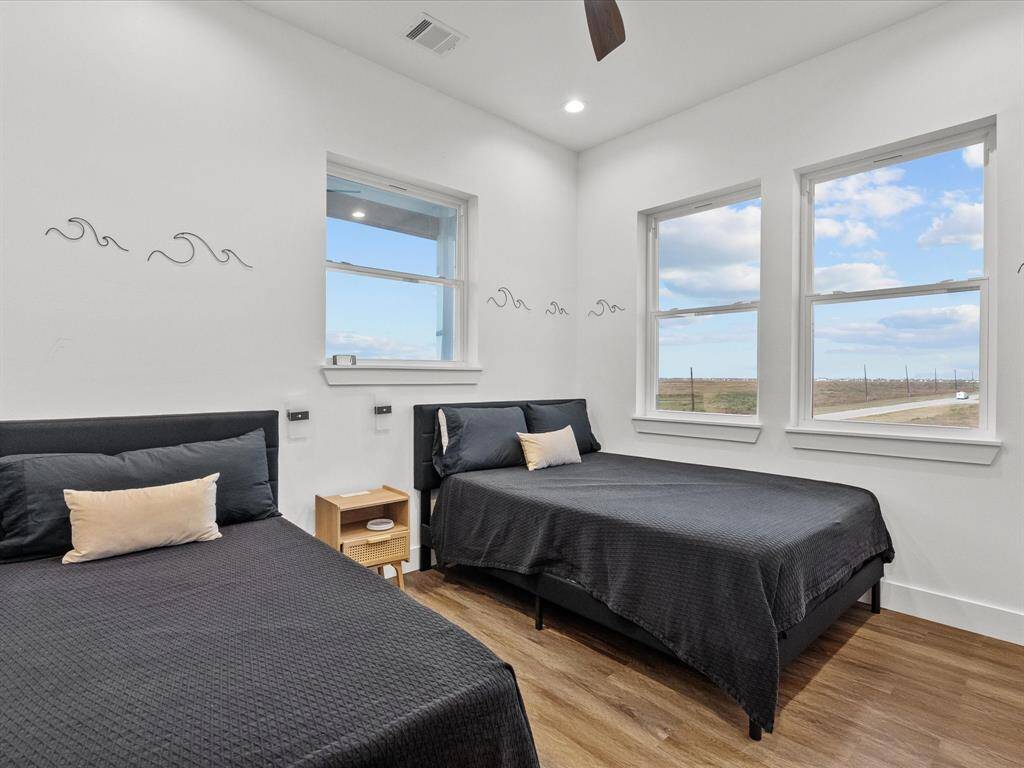Spacious fifth bedroom featuring ample natural light and serene views, perfect for guests or a home office.