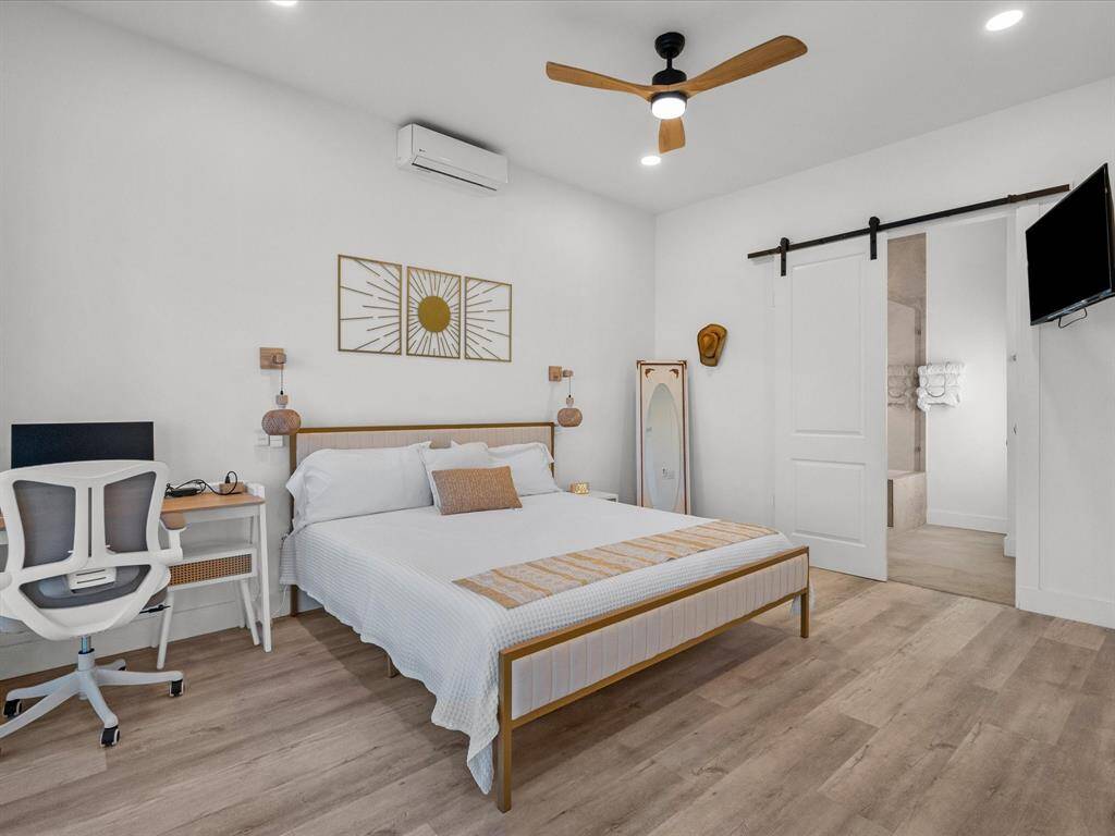 Spacious primary bedroom with modern décor, featuring a cozy ambiance and convenient ensuite access.