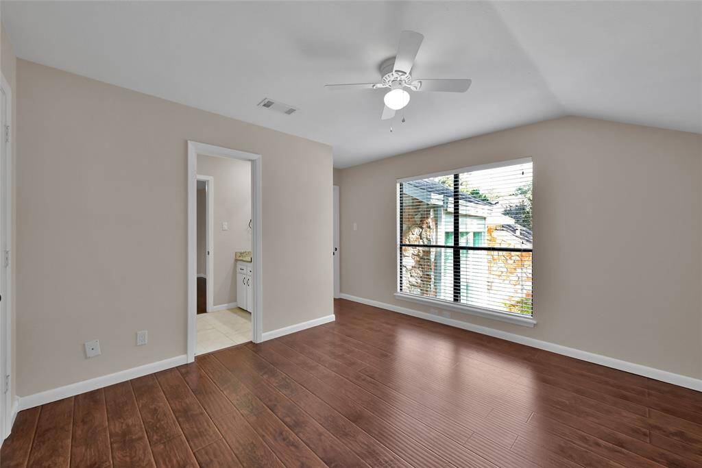 Front secondary bedroom offers access to a shared bathroom, and large windows allowing for natural light.