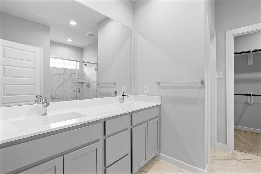 This primary bathroom is definitely move-in ready! Featuring stained cabinets with light countertops, dual vanities, spacious walk-in closet with shelving, high ceilings, custom paint, sleek modern finishes.