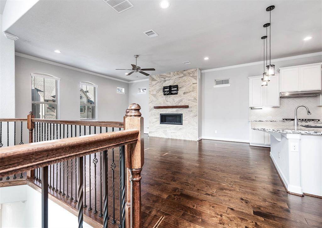 2nd floor open concept family/living room and kitchen area features abundant natural lighting and a beautiful fireplace with accent tile surround.
