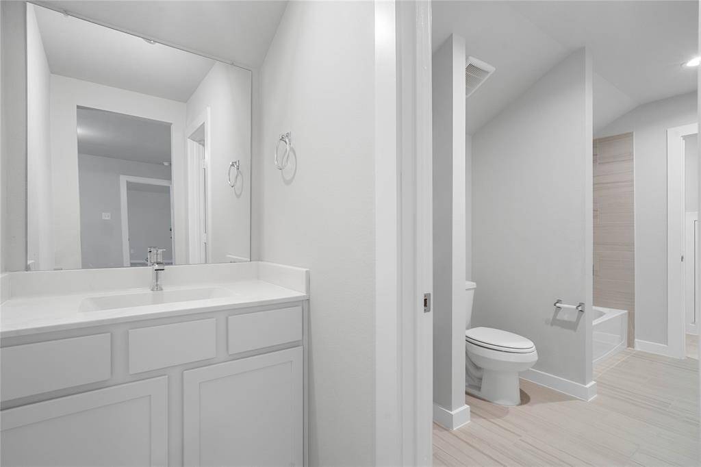 Additional feature of the primary bathroom is this oversized, framed walk-in shower with tile surround.