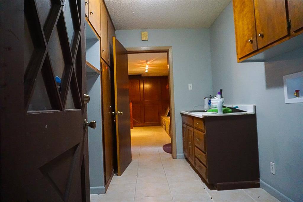 Sink located next to washer and dryer area.