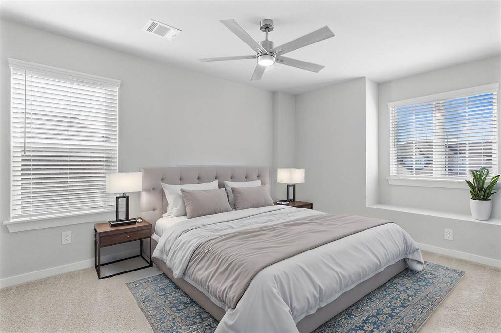 Secondary bedroom features plush carpet, custom paint, high ceilings with ceiling fan, and large windows with privacy blinds.