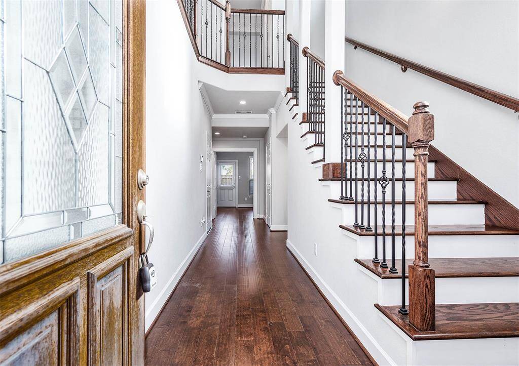 Beautiful 3 story entry showcasing the home's wooden stair risers and iron spindles.