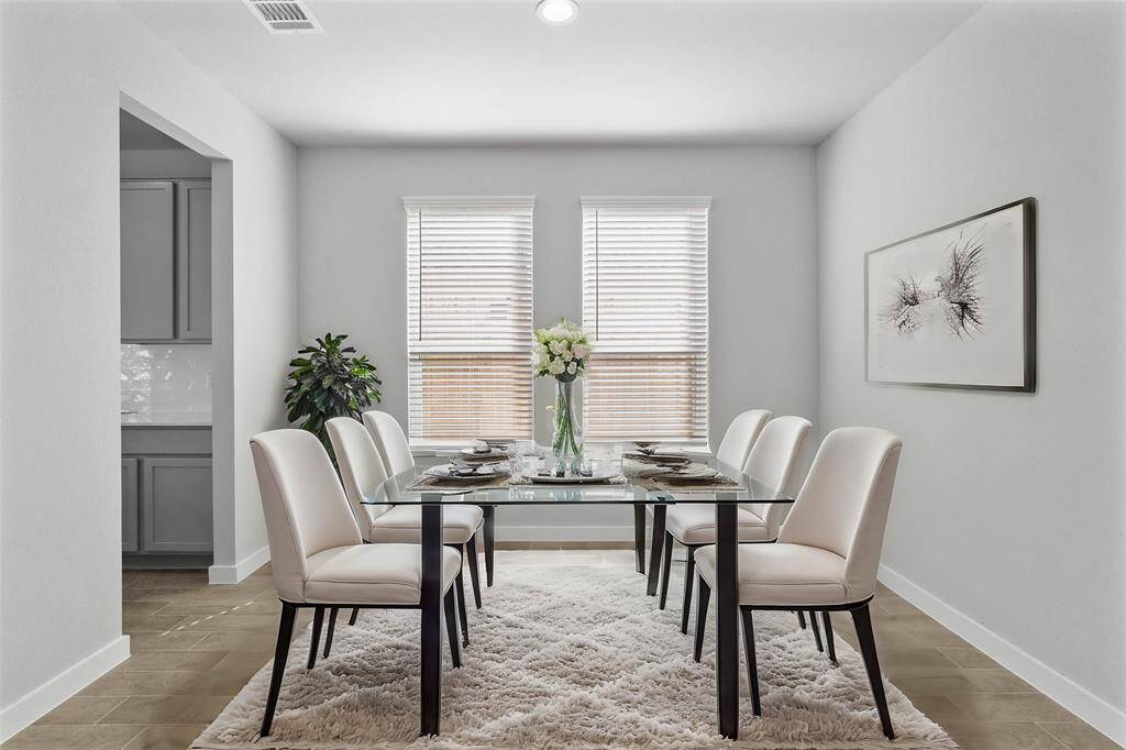 You and your guests will certainly dine in style in this amazing formal dining room! Featuring large windows with privacy blinds, neutral paint, high ceilings, and wood look tile flooring! Perfect space to entertain family and friends!