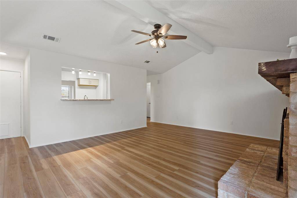 Another view of the living room, peeking into the kitchen. The door on the left goes to the garage.