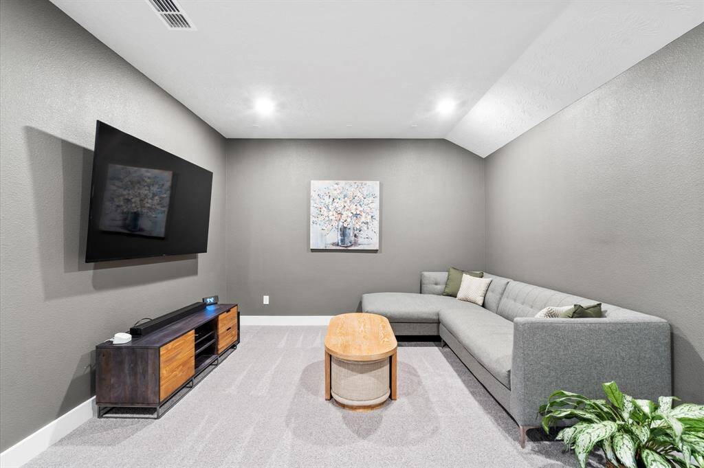 The second bedroom is bright and cozy, with soft carpeting, a neutral color palette, and a window overlooking the neighborhood.