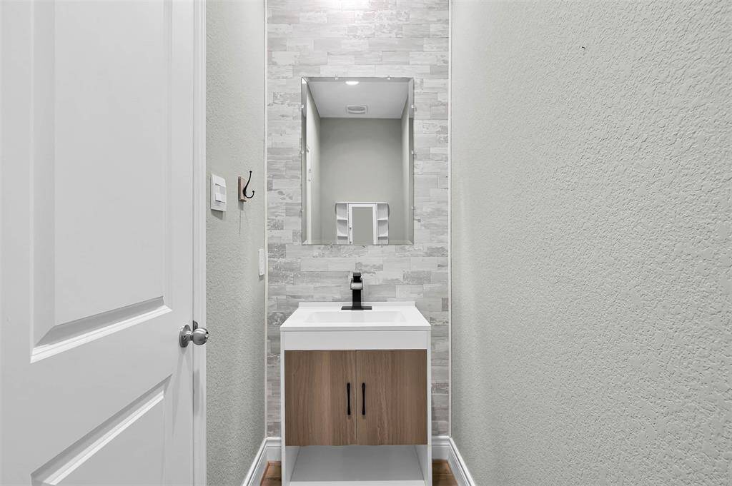 Half Bath with Accent Wall and Upgraded Vanity.