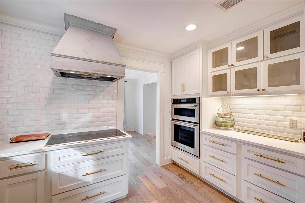 Kitchen has window over large farm sink and custom shelves for a trendy look.Deluxe  Drawer and cabinet fixtures Easy to keep the kitchen clean with subway tiled walls