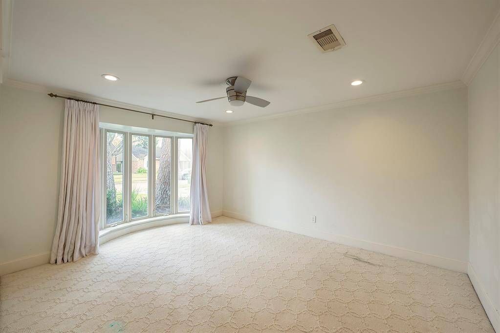 Primary Bedroom has drapes by French door to yard, chandelier. Door leads to primary bath