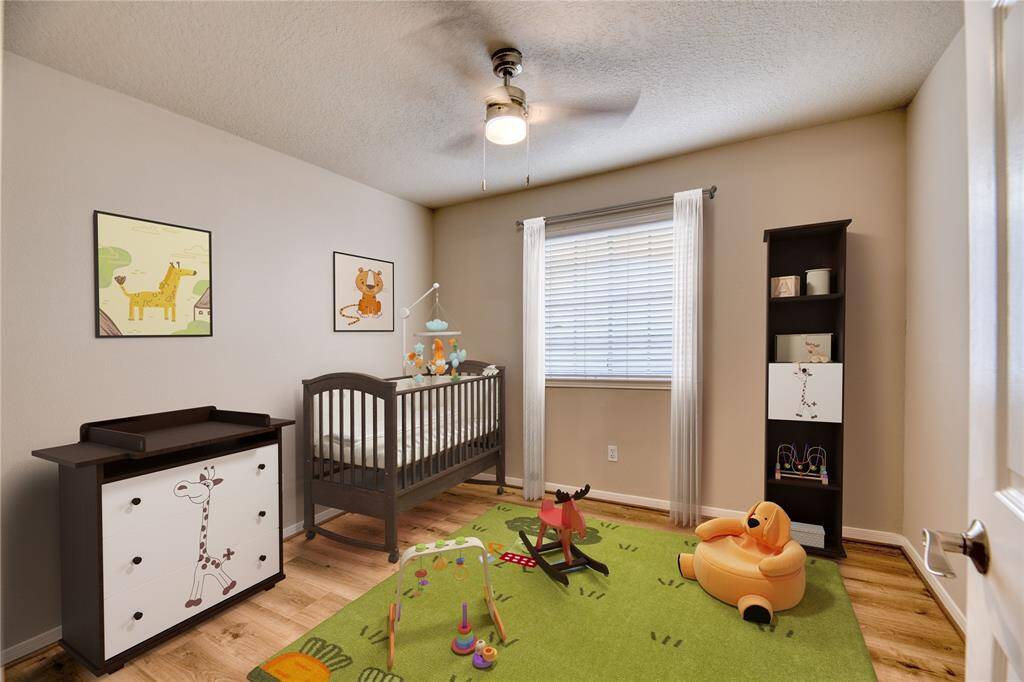 Bright and airy secondary bedroom with a ceiling fan and ample natural light.