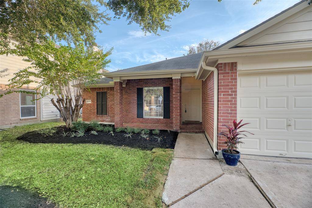 Charming single-story brick home with a welcoming front porch and attached garage. Features a well-maintained lawn, landscaped garden, and a cozy entryway. Perfect for comfortable living in a friendly neighborhood.