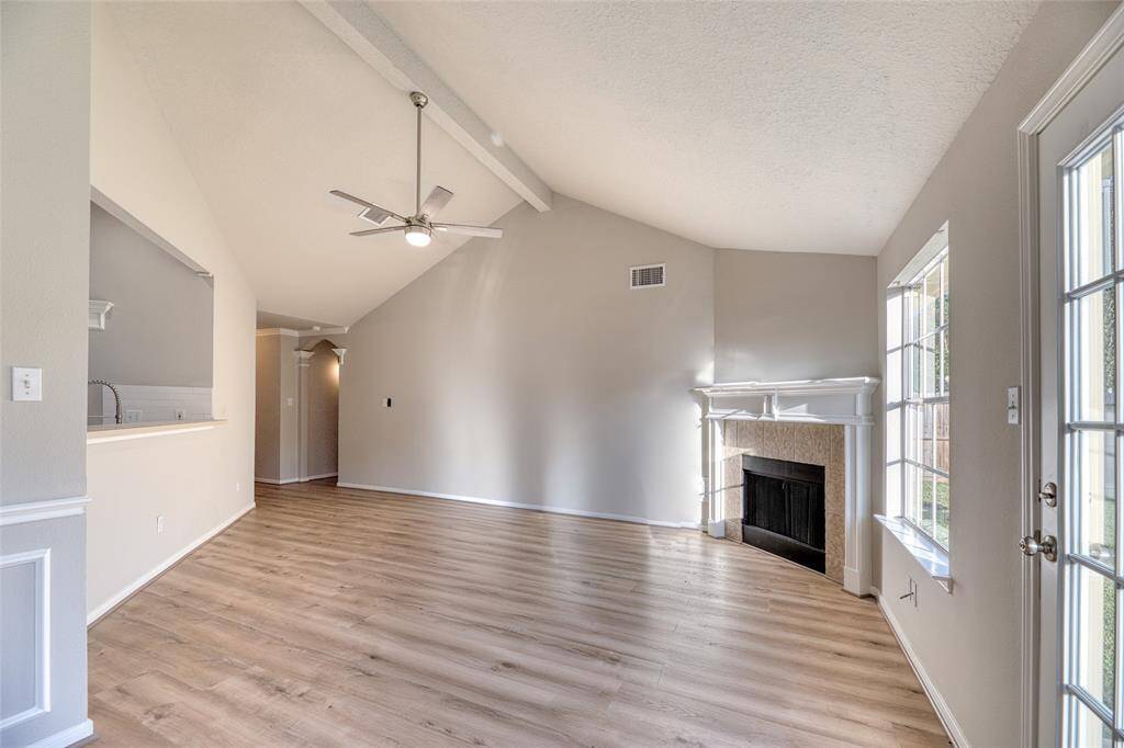 Experience the charm of a spacious living room with soaring ceilings and a welcoming fireplace.