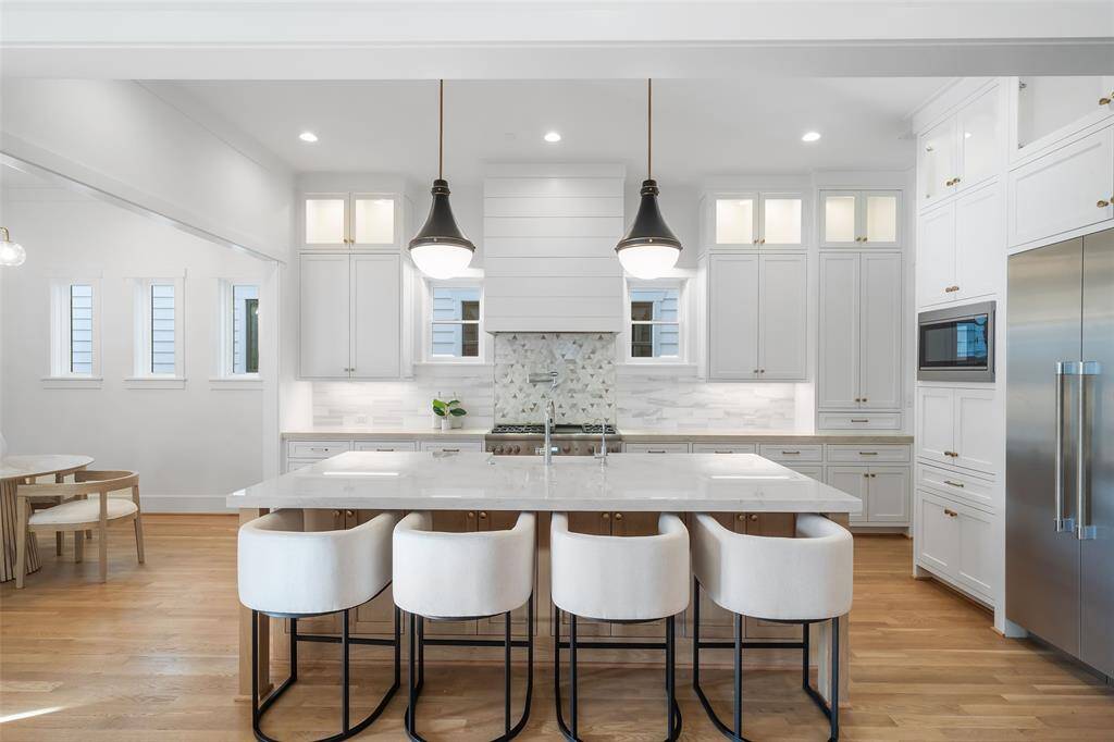Enjoy this elegant kitchen with quartzite counter tops, Thermador stainless steel appliances, white oak island, and custom cabinets