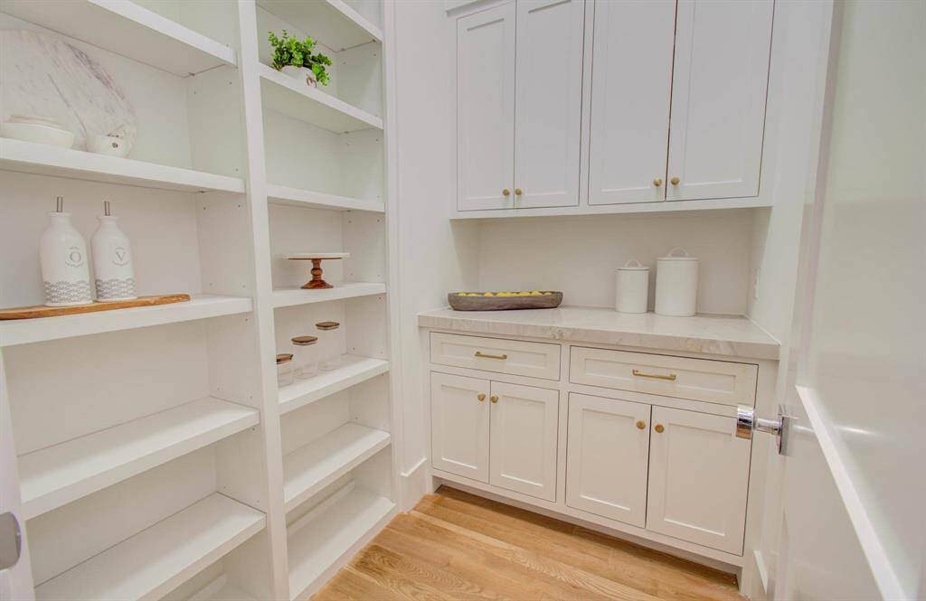 Walk in pantry offer a Quarzite counter top and custom built cabinets.