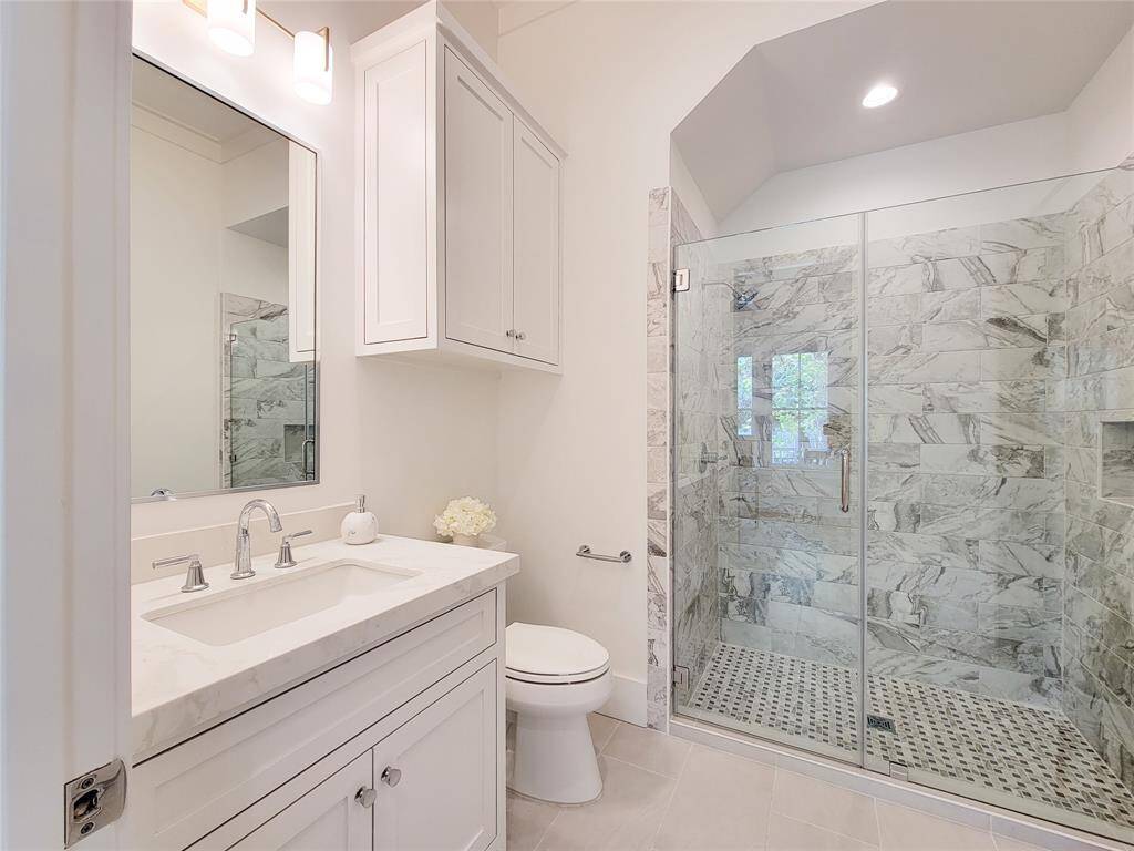 Full bathroom located on the first floor offers a walk in shower with a glass door. Beautiful tile and lighting. All Cabinets built-in sight.