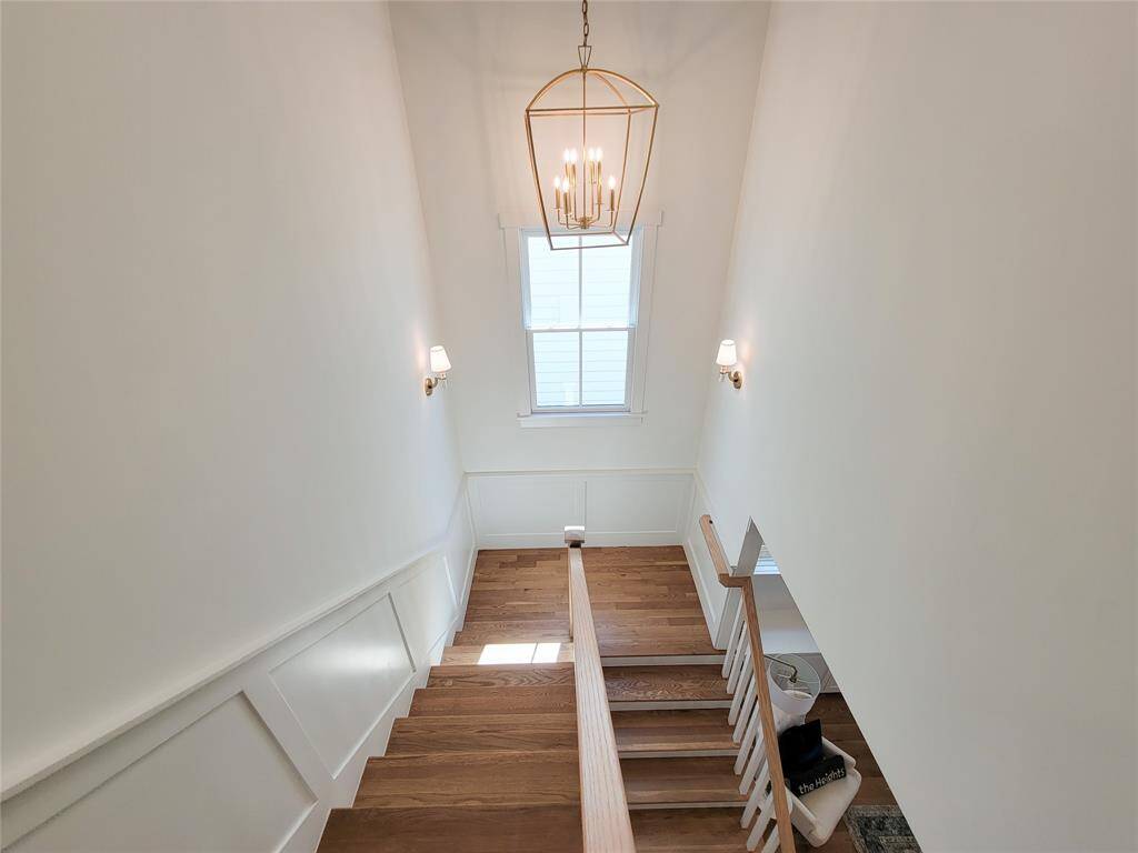 Enjoy this beautiful staircase. White oak floors with a natural finish and an exquisite chandelier.