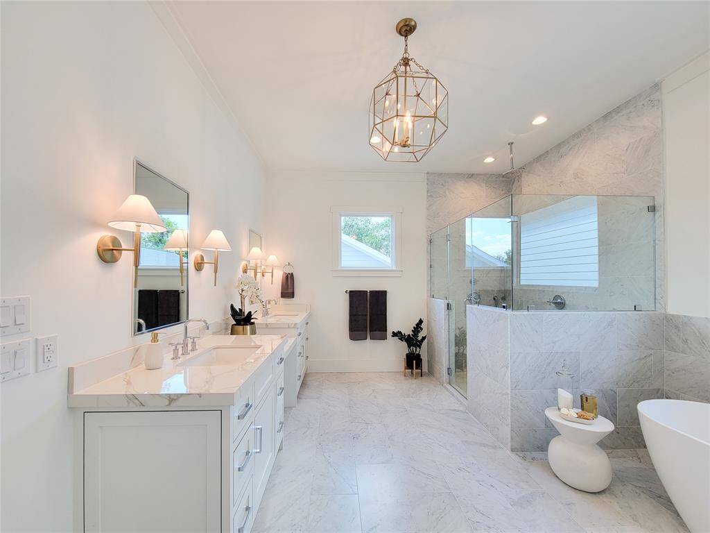Primary Bath offers double sinks, quartzite countertops, and beautiful lighting.