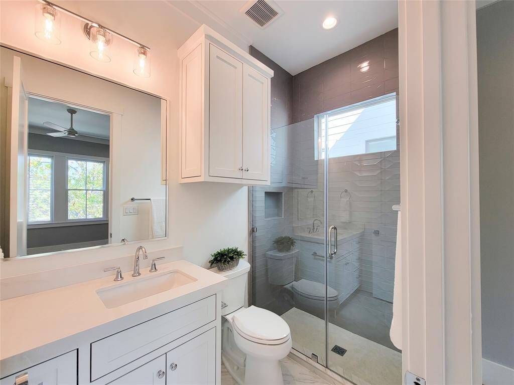The first secondary bedroom upstairs, faces the street, it offers natural light, closet, and ensuite bathroom with a shower.