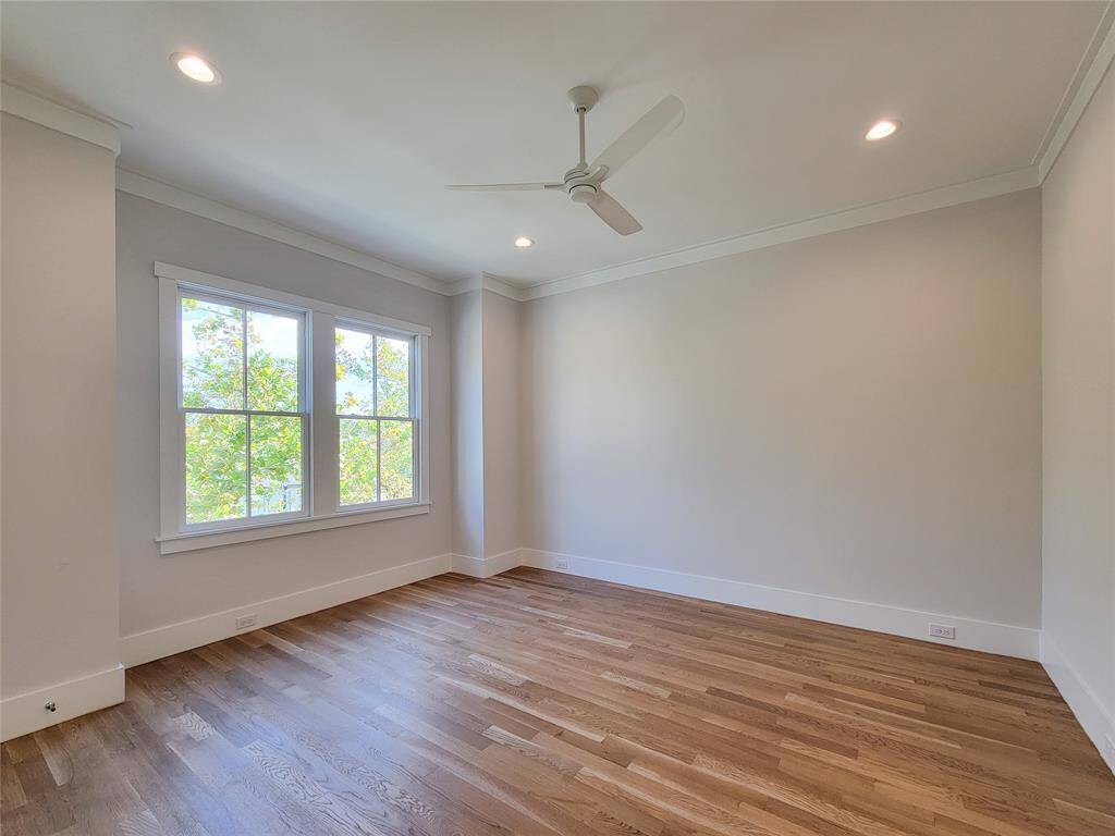 The first secondary bedroom upstairs, faces the street, it offers natural light, closet, and ensuite bathroom with a shower.