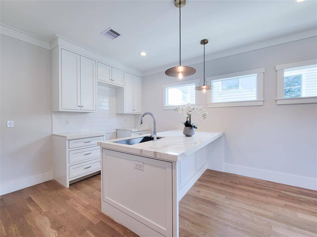The garage apartment kitchen. Full island quartzite counter tops and modern lighting.