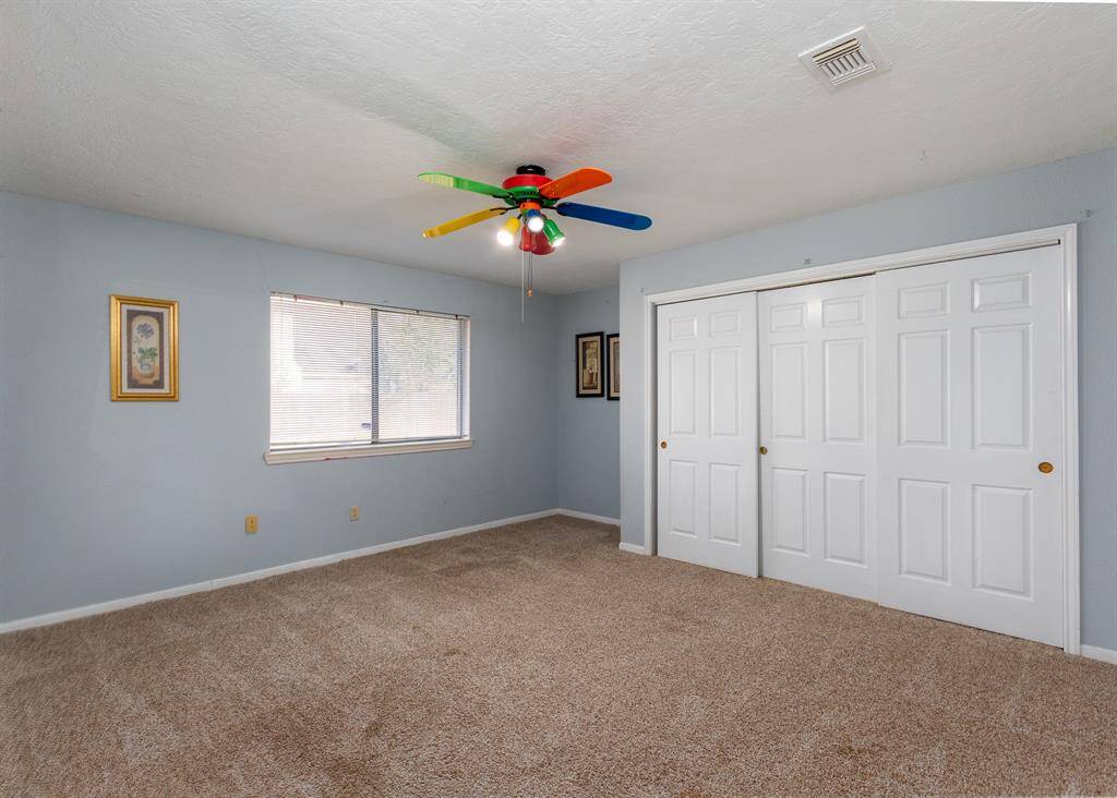 Spacious 2nd bedroom with triple wide closet and views of the backyard.