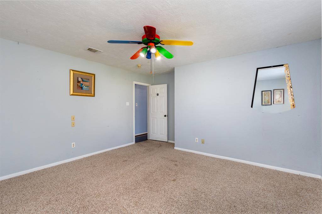 The 2nd bedroom features neutral carpet & ceiling fan
