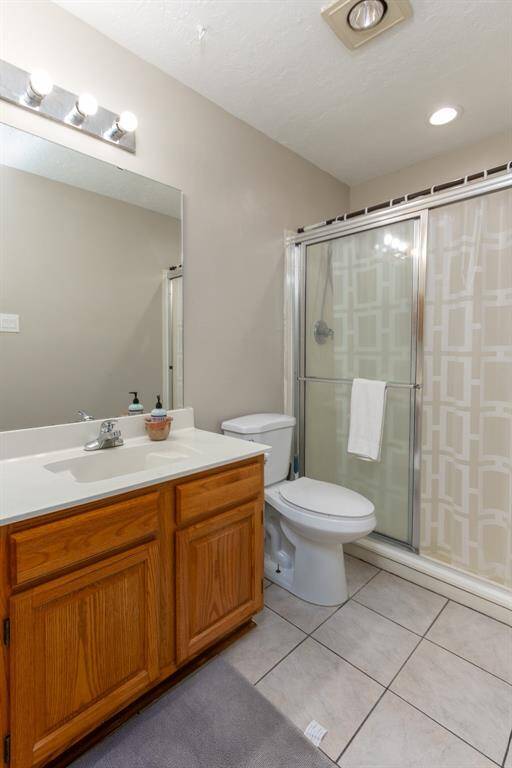 2nd Bathroom with pretty tile floors and walk in shower with glass sliding door.