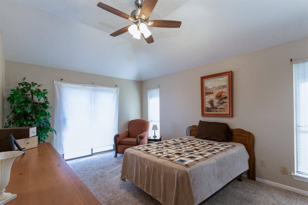 The spacious primary suite offers high ceilings w/ceiling fan, large walk-in closet and neutral carpet.