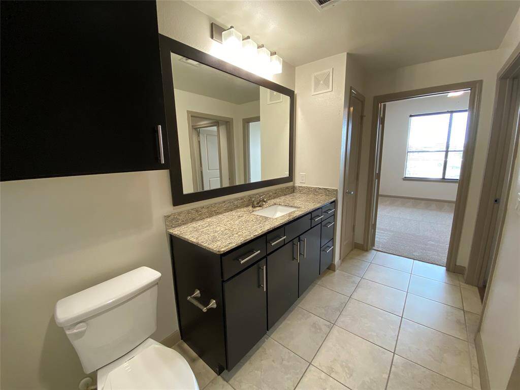 Granite single vanity, tiled floors, and connected to the bedroom