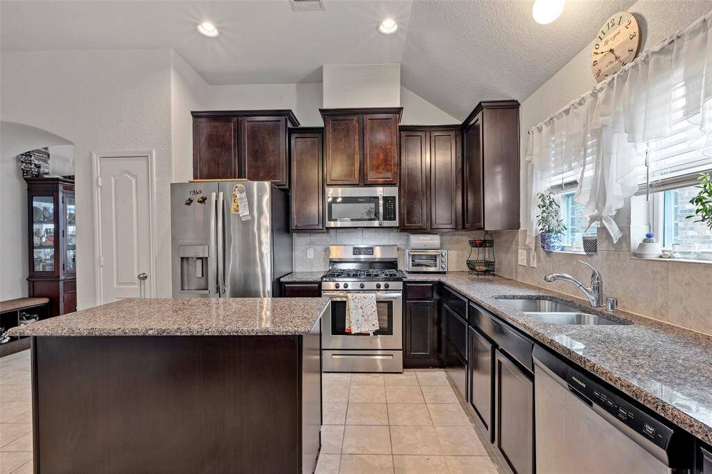 Get a closer look at the sleek stainless steel appliances and stunning granite countertops.