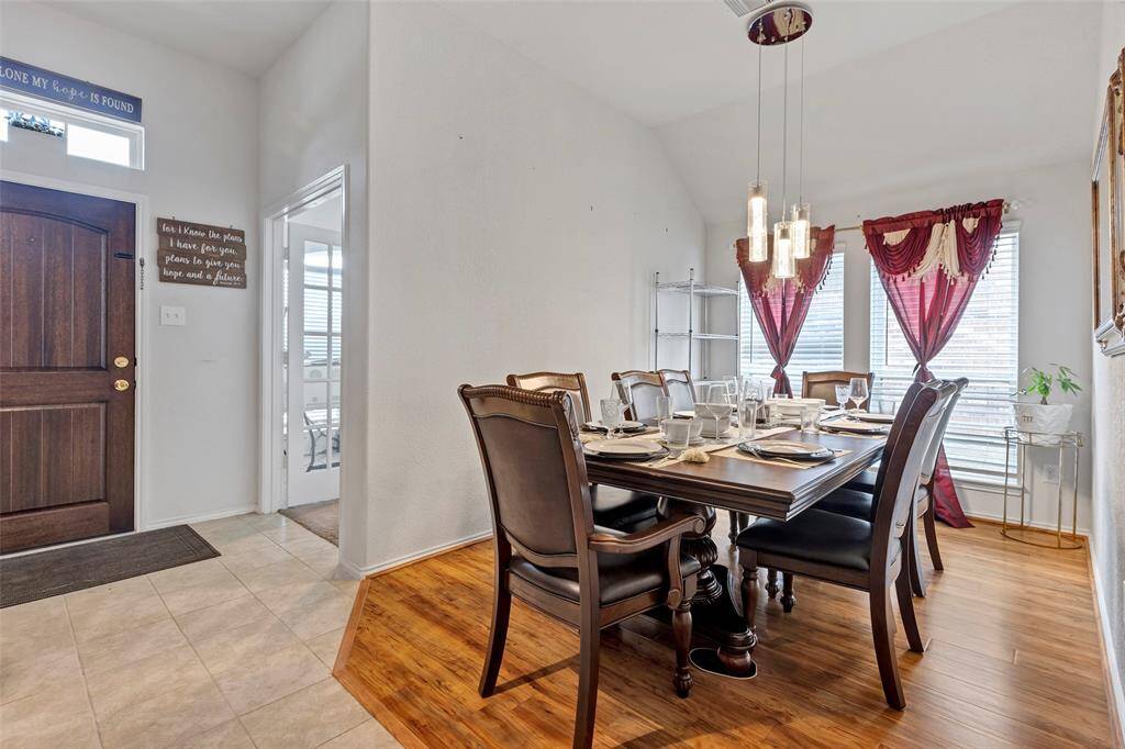 Set the stage for memorable meals in the formal dining room, featuring stunning drop lights and elegant hardwood floors.