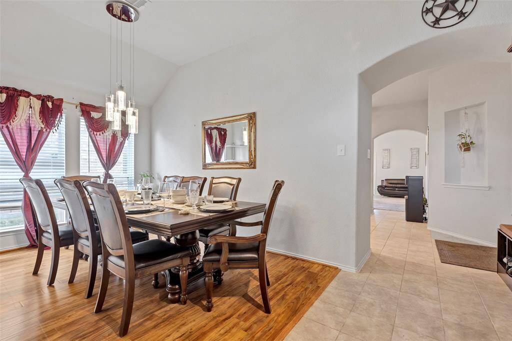 An enhanced view of the dining room, offering a glimpse of the spacious living room through the open doorway.