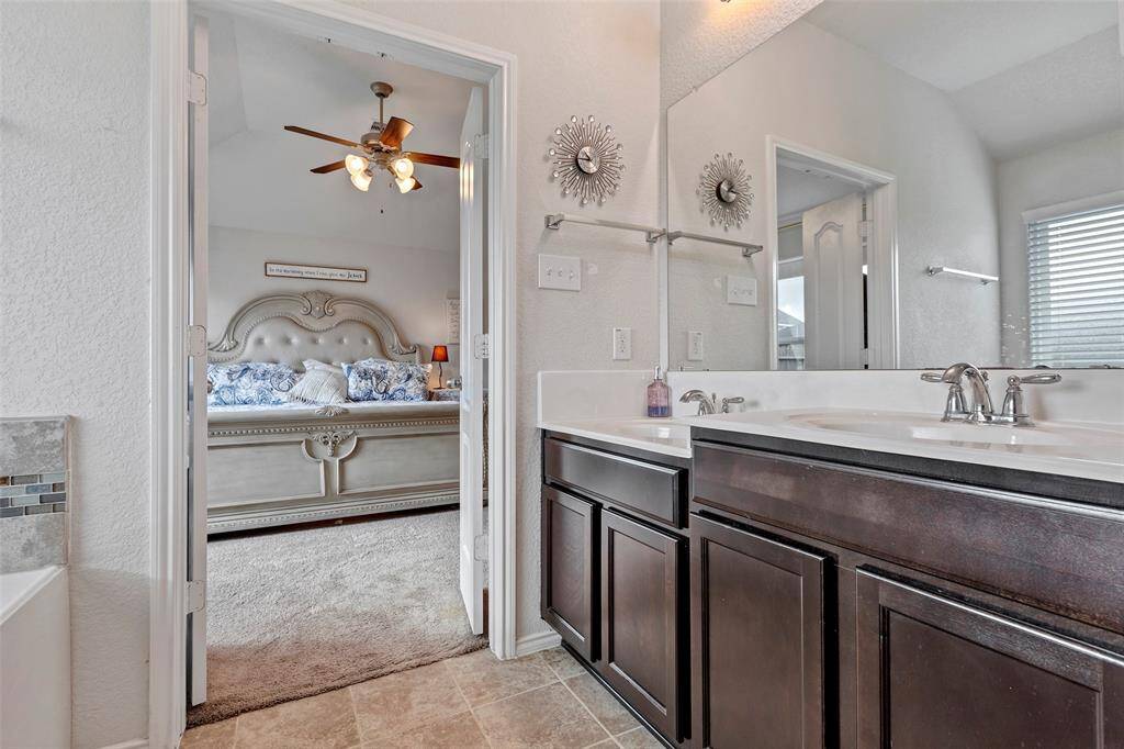 Step into the primary bathroom, featuring dual sinks and a large vanity mirror, creating a bright and functional space for everyday convenience.