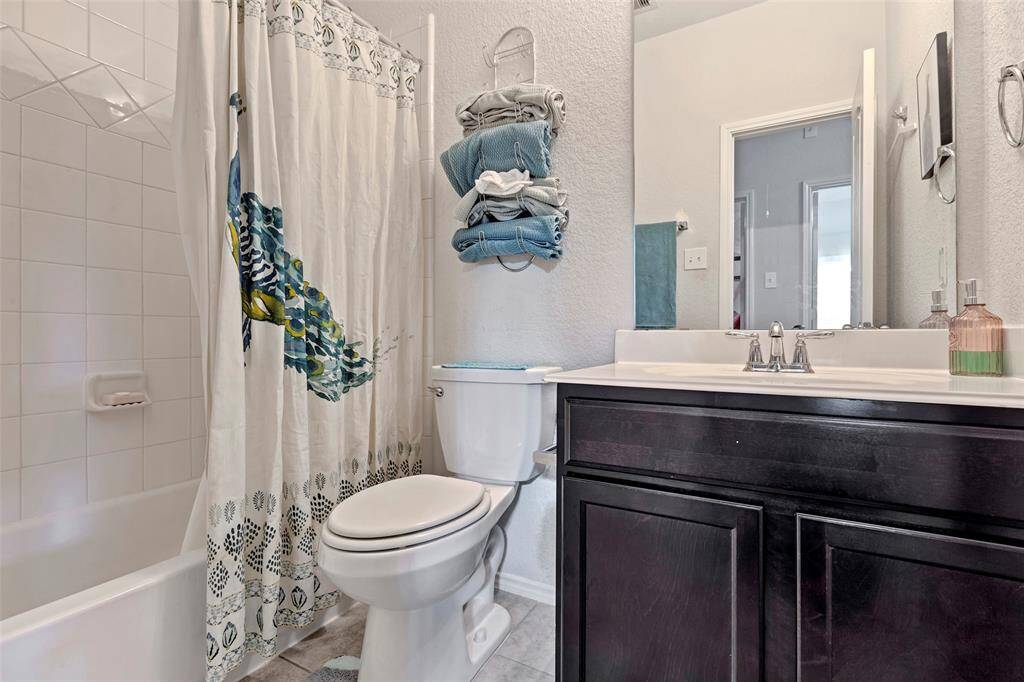This secondary bedroom features its own private bathroom, complete with a tub and shower combo, toilet, and a single sink for added convenience.