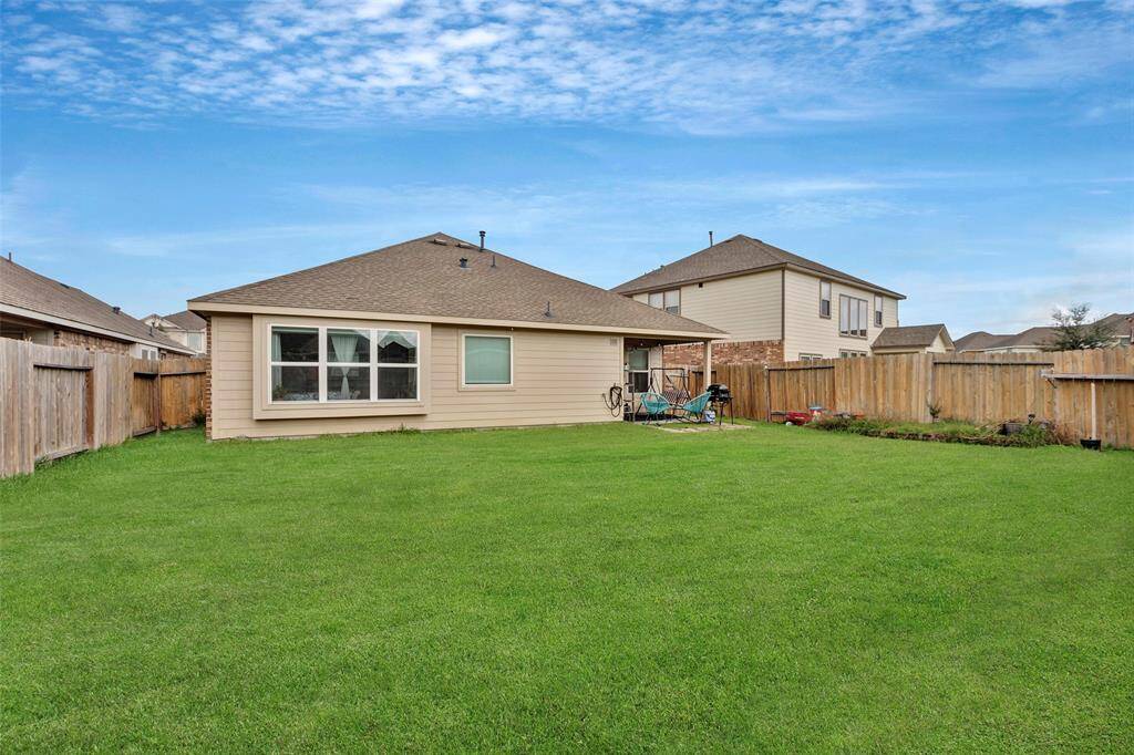 Enjoy a stunning view of the backyard, featuring lush green grass and a tall wooden fence for privacy and tranquility.